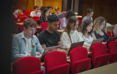 Des étudiants en amphithéâtre prennent nots lors d’un cours du Master Expertise Internationale